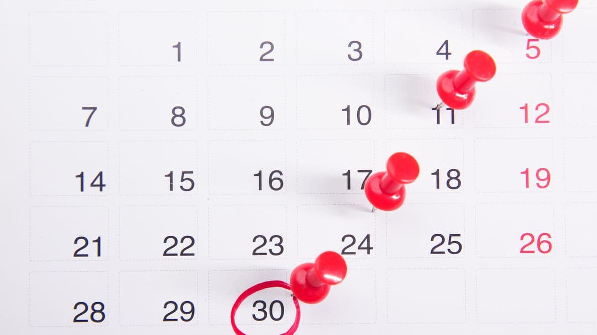 A wall calendar with a run of dates marked by red pushpins, ending on the 30th circled in red